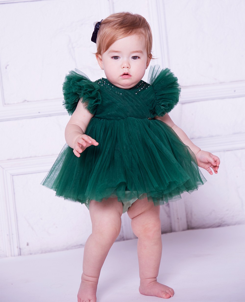 Baby Girl Elegant Dress. A One-year-old Girl In A Puffy Dress And A Cute  Bow Poses Against The Backdrop Of A Bright Room With A Dressing Table And  Flowers. Stock Photo, Picture